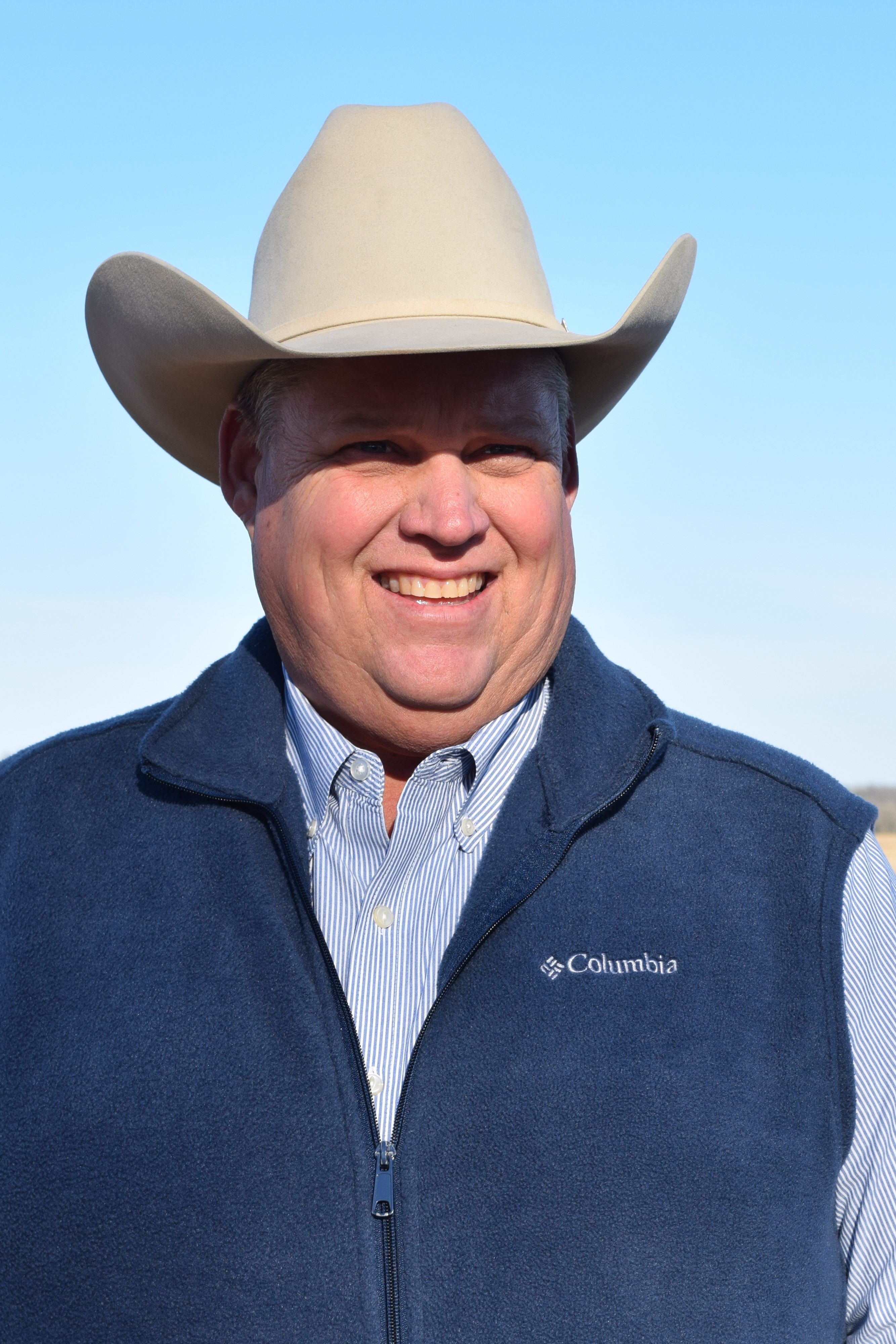 Owner Gregg in a white cowboy hat, dark blue vest and light blue shirt